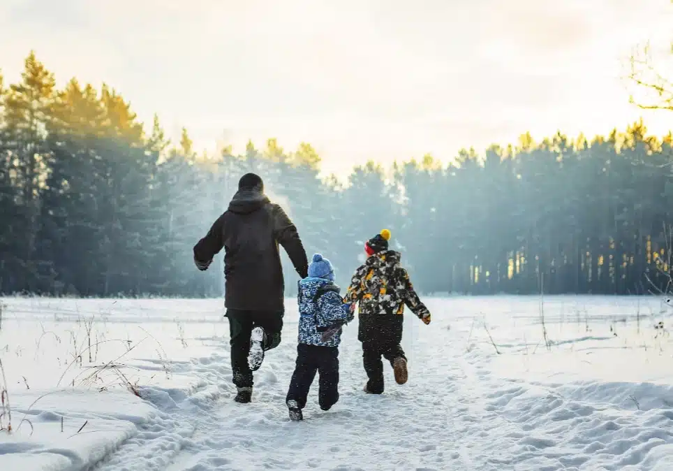 Familie beim Winterspaziergang im Schnee – Weihnachten im Barfußland